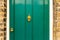 Background of vintage green painted door and knocker vignette look made of old fashioned vintage brass metal