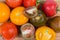 Background of whole and sliced varicolored tomatoes on wooden surface