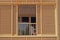 Background with a window and balcony surrounded by a wooden blind on a warm summer day