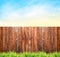 Background with wooden fence , grass and blue sky
