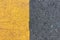 Background of yellow black strips . Dark grey asphalt road divided by yellow pain