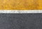 Background of yellow black strips . Dark grey asphalt road divided by yellow paint