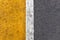 Background of yellow black strips . Dark grey asphalt road divided by yellow paint