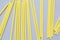 Background of yellow cocktail party paper straws on gray background. Trendy colors of the year 2021.