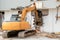 A backhoe demolishing a building