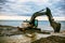 Backhoe or digger working with bucket at industrial earth excavation site