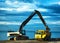 Backhoe or digger working with bucket at industrial earth excavation site