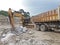 Backhoe digging for gypsum ore And loaded at the ten-wheeled truck at the mine