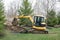 Backhoe Digging out Tree Stump