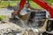 Backhoe excavator scoop loading from building in the construction debris dump truck