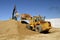 Backhoe and front end loader moving sand