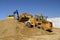 Backhoe and front end loader moving sand