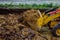 Backhoe loader moves clay soil in the excavation to the dump