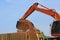 Backhoe Loading Woodchip into Truck