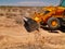 Backhoe machine scraping the dry desert in Arizona