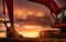 Backhoe parked at construction site after digging soil. Bulldozer on sunset sky and clouds background. Digger after work. Earth