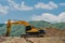 Backhoe at rest on top of dirt hill at construction site