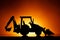 Backhoe tractor silhouette, orange background