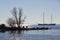 Backlight silhouet breakwater in sparkling sea with passing sailing schooner