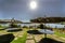 Backlight of umbrellas on the terrace of a restaurant on the lake shore formed by the Cecebre reservoir with the sun facing