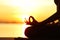 Backlight of woman silhouette doing yoga exercise at sunset