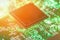 Backlit green printed circuit board with the processor is burning orange, background texture