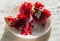 Backlit pieces of splitted pomegranate fruit on the white dish