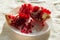 Backlit pieces of splitted pomegranate fruit on the white dish