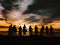 A backlit shot of a group of cycling friends standing in line at sunset