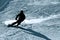 Backlit silhouette of man in action practicing ski going fast and agressive down snow slope winter sport