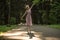 Backlit silhouette of young ballerina dancing in the park with dancing shadow on the ground