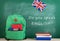 backpack, blackboard with text "Do you speak English?", flag of the Great Britain, calculator, books and notebooks