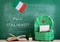 backpack, blackboard with text "Parli italiano?", flag of the Italy, books and notebooks