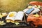 The backpack and the book rests on a antique wooden table, notebooks, phones and the nature of maple leaves from the top view