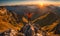 Backpack-clad traveler standing atop a mountain, overlooking a panoramic vista in the late afternoon