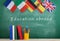 backpack, flags of Spain, France, Great Britain and other countries, books and school supplies of the blackboard