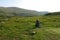 Backpack on the meadow with mountains on the background. Summer hiking motivational image. Space for text