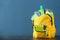 Backpack with school supplies on grey table against color background