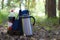 Backpack, thermos and bottle with a drink, rest in nature, vacation time and weekends.