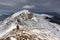 Backpacker climbing a mountain snowy ridge winter