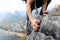 Backpacker climbing rock on mountain top cliff edge