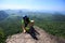 Backpacker climbing up on seaside mountain rock