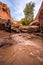 Backpacker crossing small stream Coyote Gulch