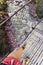 Backpacker crossing suspension bridge and looking down in Himalayas Nepal