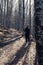 Backpacker Girl smiling hiking in the forest with a stick