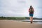 Backpacker girl traveler walk on deserted ocen beach