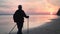 Backpacker grandfather beach sunset sunrise sun sea scenery walking stick health lifestyle back view