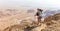 Backpacker guy standing trail looking mountains desert view.