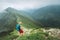 Backpacker hiker man walking by the foggy cloudy weather mountain range path with backpack. Active sport backpacking healthy