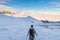 Backpacker hiking on snow on the Alps. Rear view, winter lifestyle, cold feeling, majestic mountain landscape.